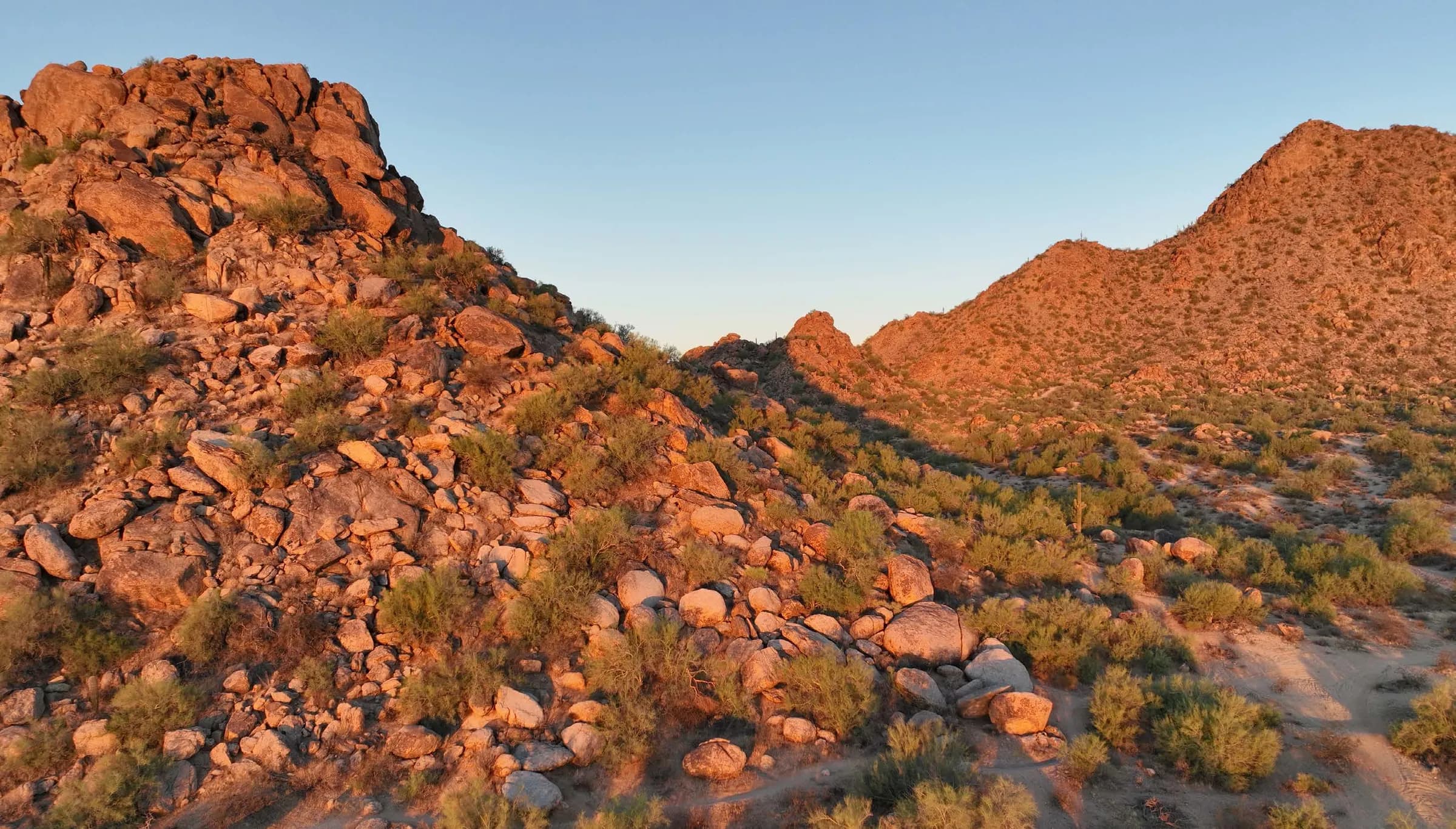 A boulder-covered hillside in the North Phoenix desert at golden hour